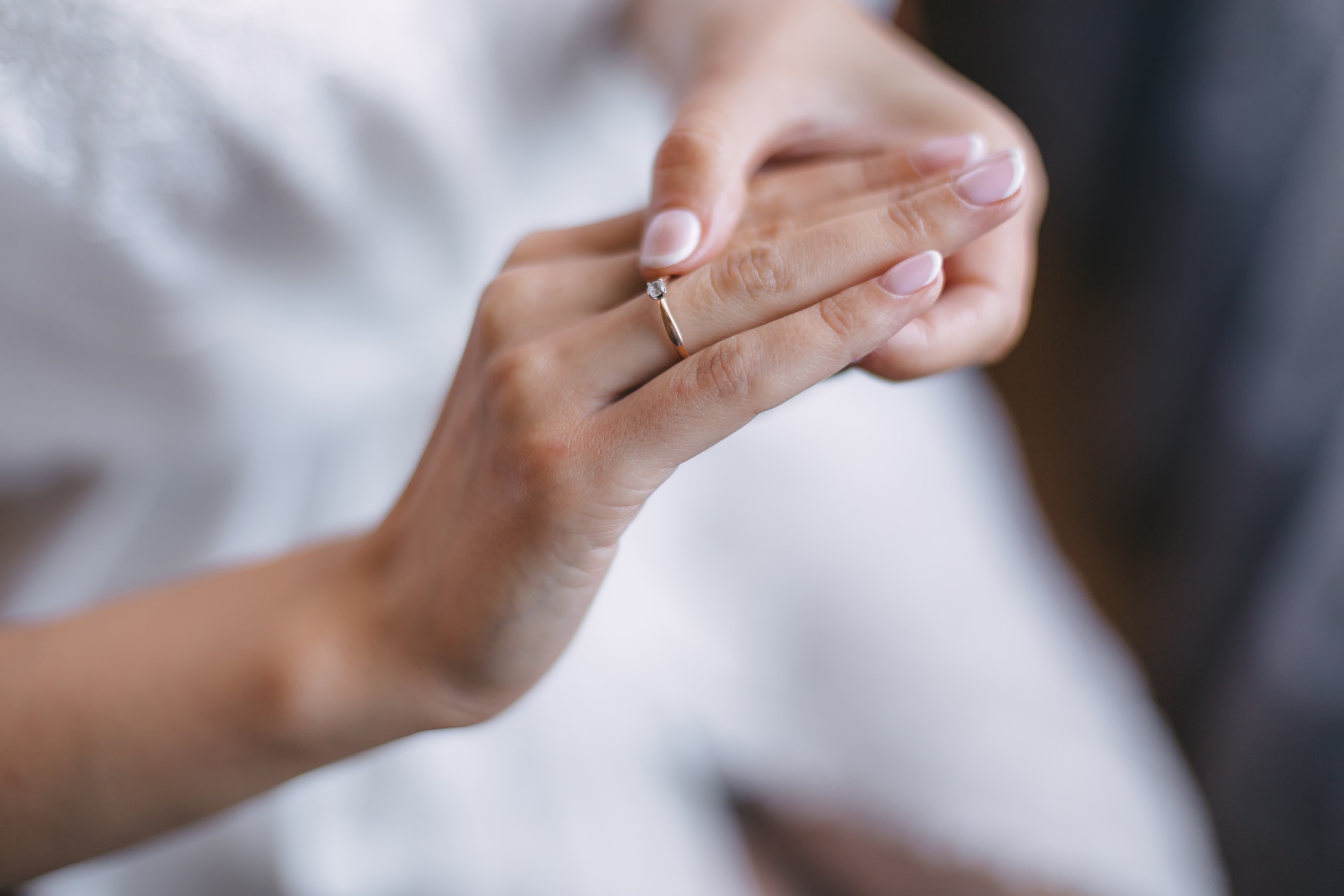Hand beim Anlegen eines schlichten Rings | Eheringe


