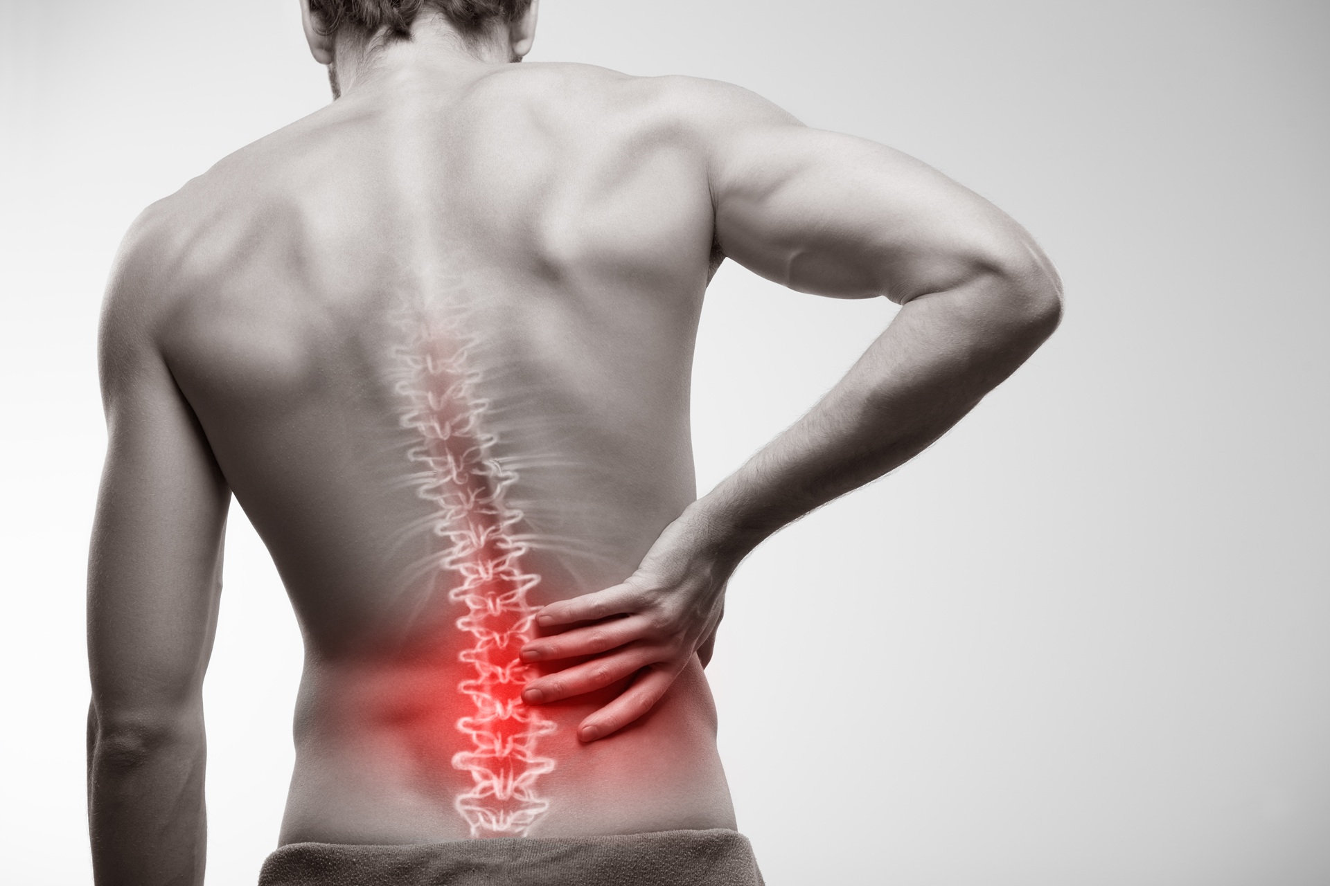 Mann mit Rueckenschmerzen und markierter Wirbelsäule | Chiropraxis Berlin